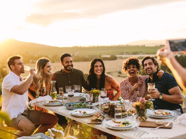 Woman taking picture of her friends at dinner party