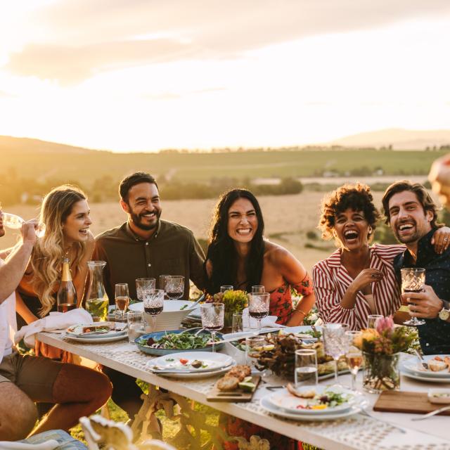 Mujer fotografiando a sus amigos en una cena